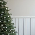 Fotohintergrund: Weihnachtsbaum mit Geschenken vor heller Wand